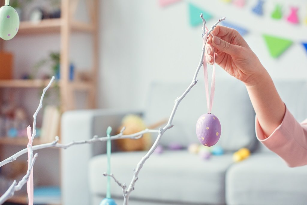 Woman hanging DIY Easter decorations in her home