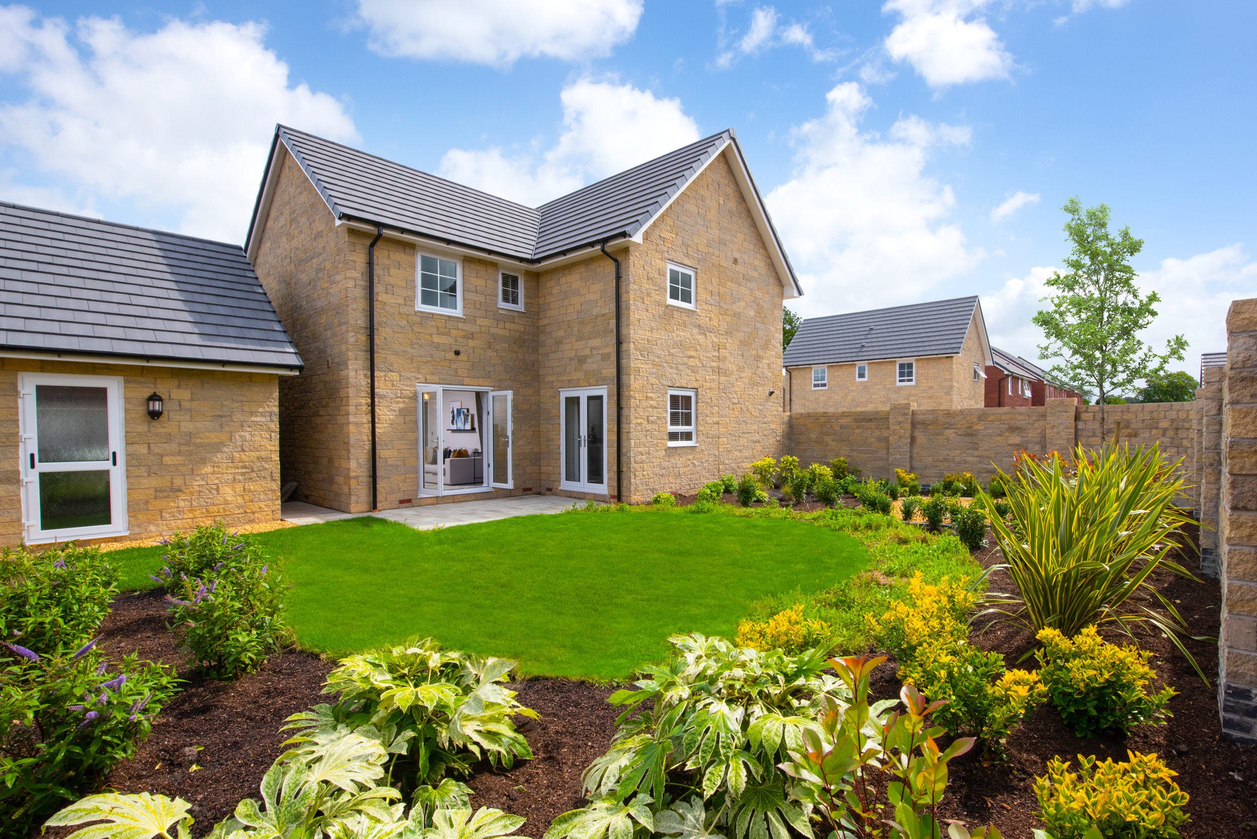 rear garden of the four bedroom detached house type the alderney showing the french doors from the home to the outside space 