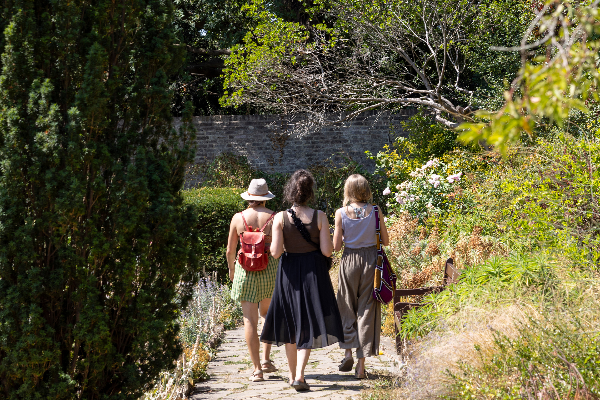 Three people walking in gardens 