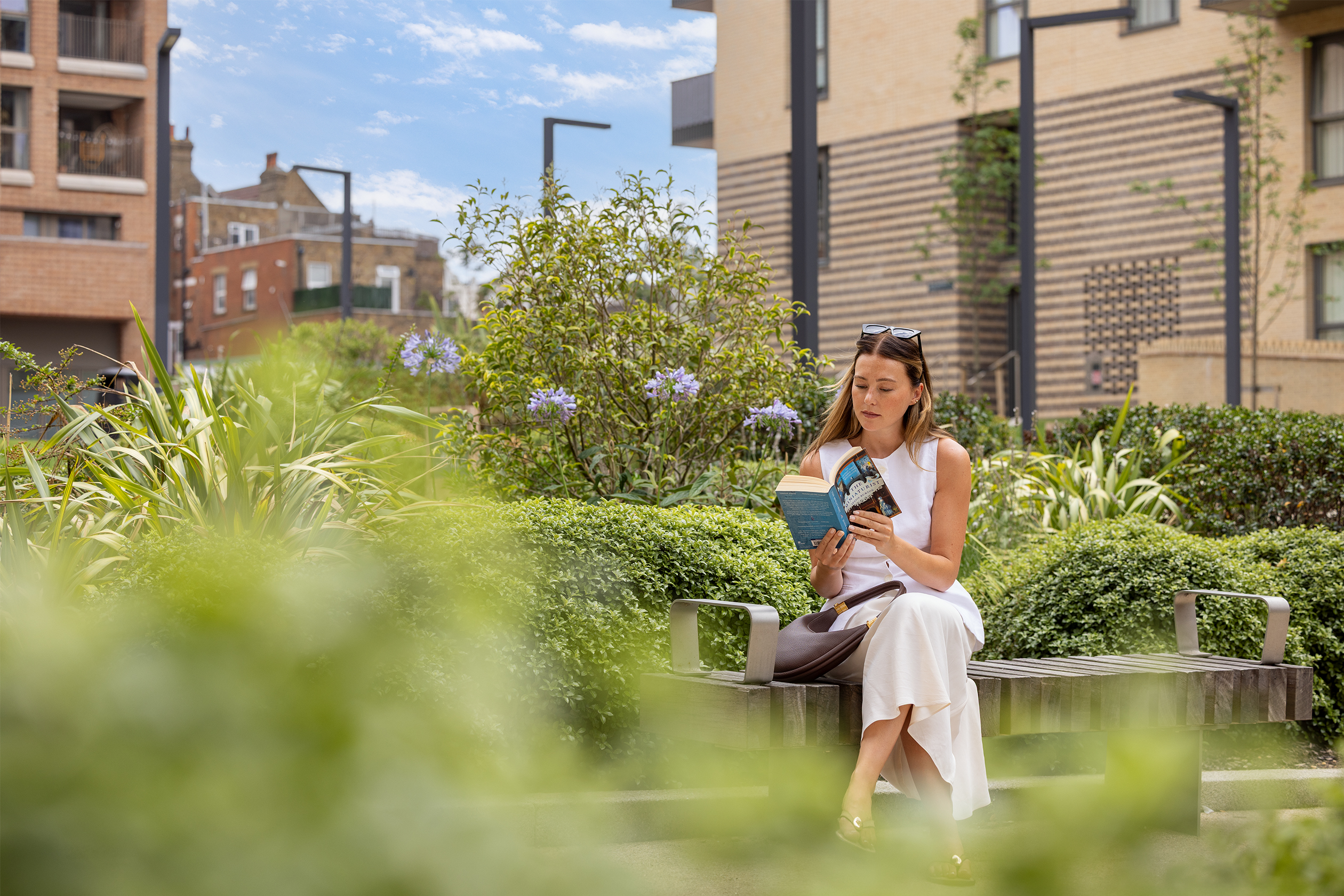 Girl reading book on bench outside